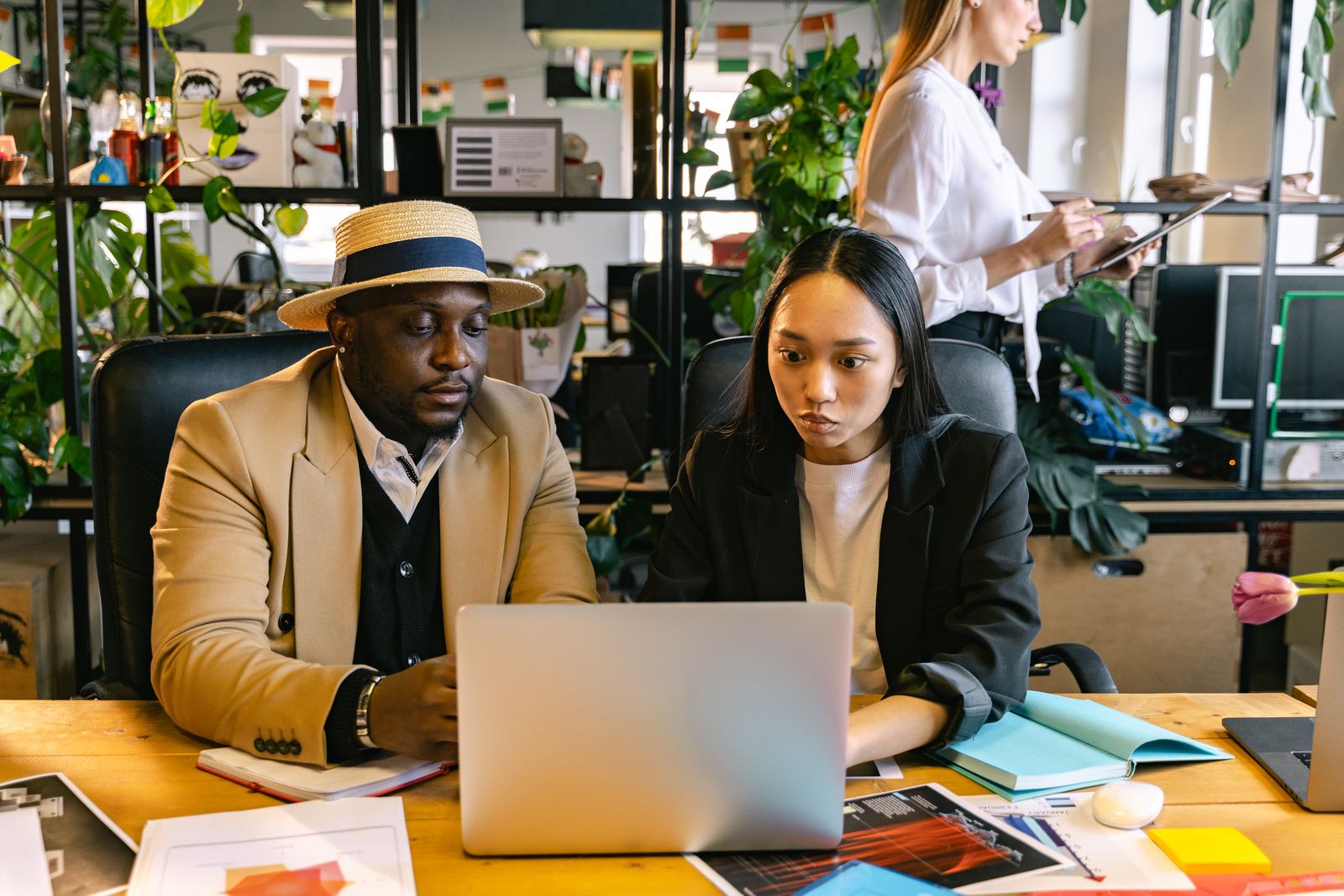 Colleagues collaborating over a laptop in a bright office