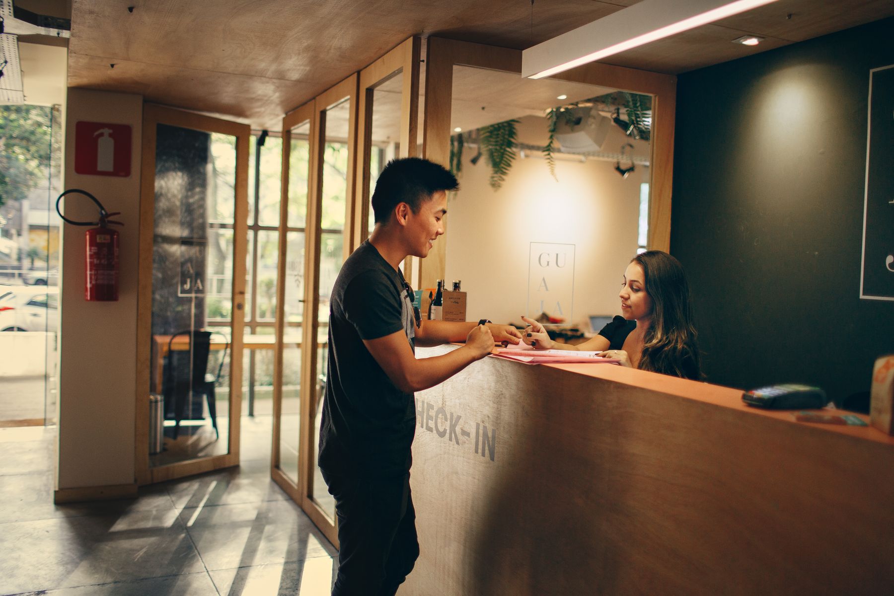 Hotel guest speaking with a receptionist at the front desk